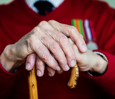 Hands of veteran with cane